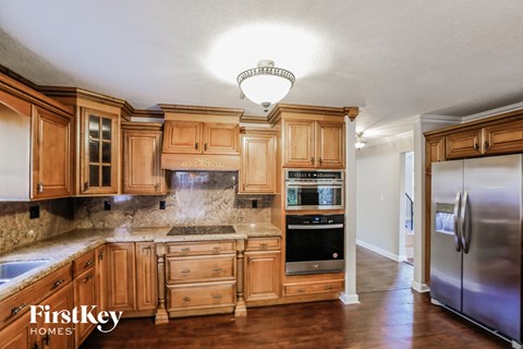 A kitchen with wooden cabinets and a stainless steel refrigerator.