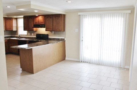 A kitchen with brown cabinets and a black stove top oven.