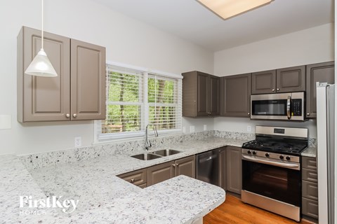A kitchen with brown cabinets and a granite countertop.