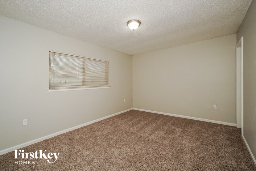 the living room of a home with a carpeted floor and a window