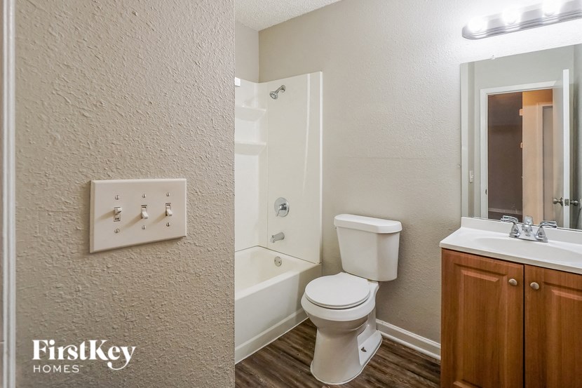 a bathroom with a toilet and a shower and a sink