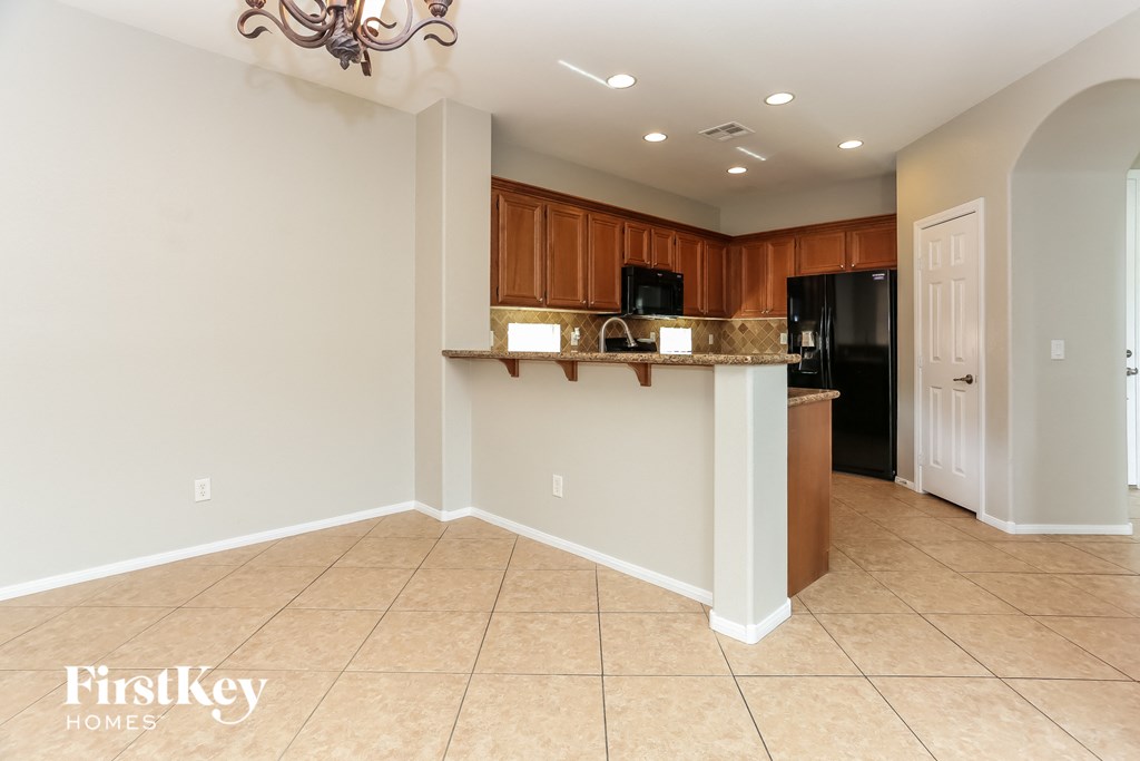 A kitchen area with a bar and a refrigerator.