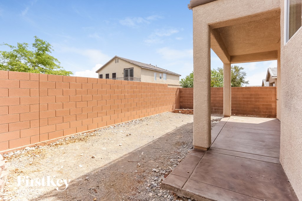 A house with a red brick wall and a concrete walkway.