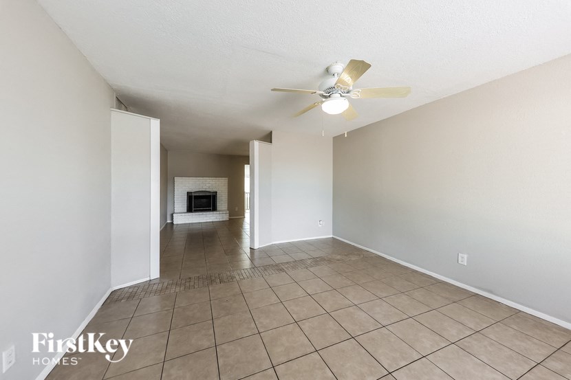 A spacious room with a fan and tiled floor.