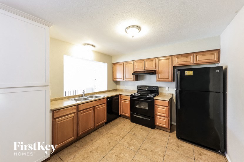 A kitchen with wooden cabinets and black appliances.