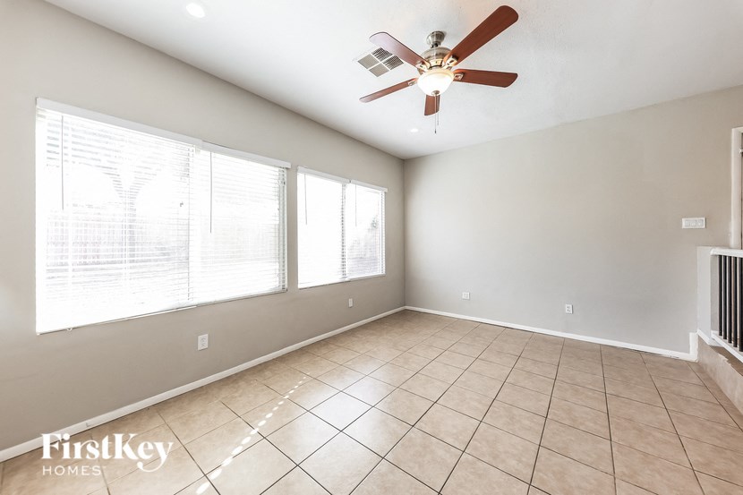 A spacious room with a ceiling fan and large windows.