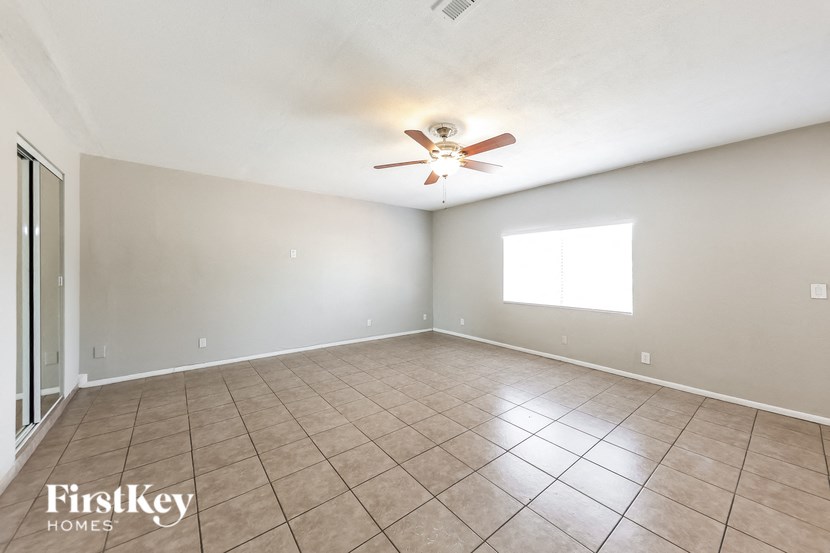 A room with a ceiling fan and a window.