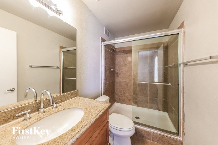 A bathroom with a sink, toilet and shower.