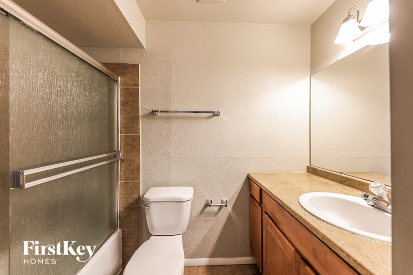 A white toilet sits next to a sink in a bathroom.