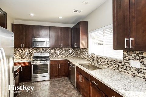 A kitchen with brown cabinets and a tiled backsplash.