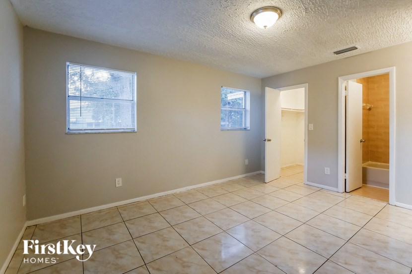 A spacious room with tile flooring and a window.