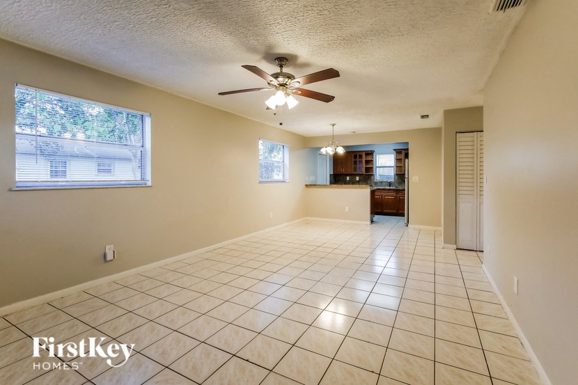 A spacious room with a ceiling fan and tiled flooring.