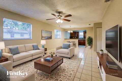 A living room with a white couch and a wooden coffee table.