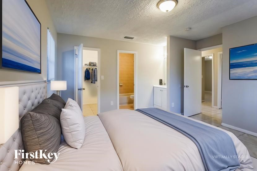 A bedroom with two beds and a painting on the wall.