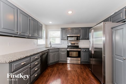 a kitchen with gray cabinets and stainless steel appliances