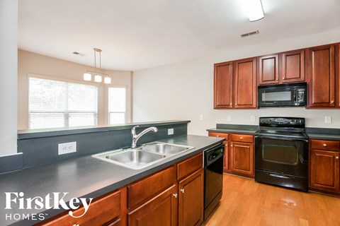 A kitchen with wooden cabinets and black appliances.