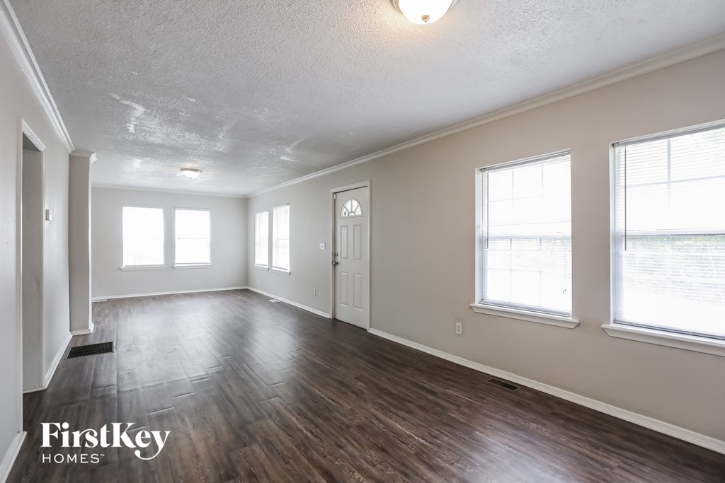 the living room and dining room of an empty house with wood flooring