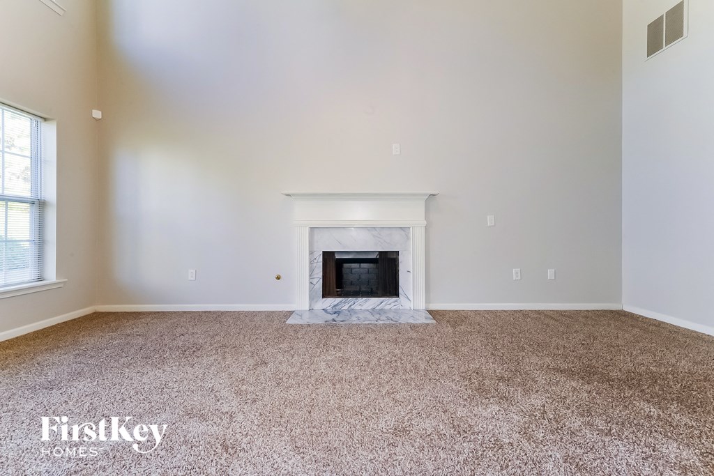 the living room of an empty house with a fireplace