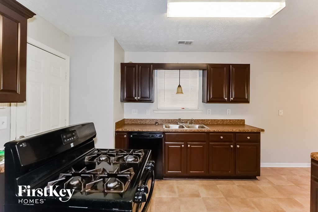 a kitchen with brown cabinets and a stove and a sink