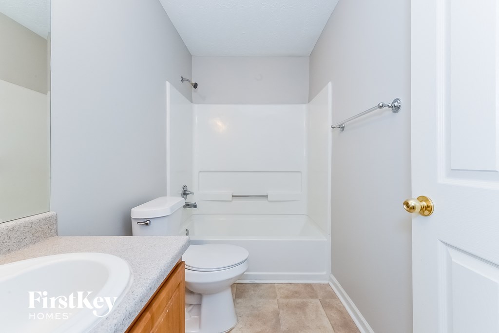 a bathroom with a toilet and a sink and a bath tub