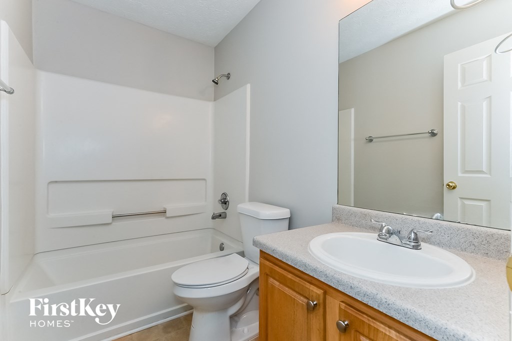 a bathroom with a sink toilet and a mirror