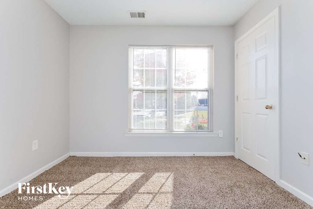 a bedroom with a large window and a white door