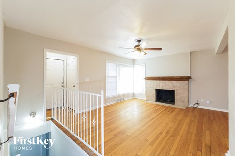 a living room with a fireplace and a ceiling fan