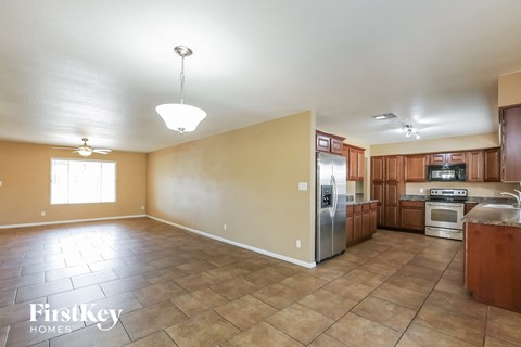 A kitchen with a tile floor and wooden cabinets.