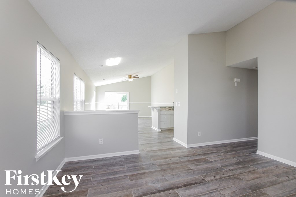 a living room with a kitchen and a large window