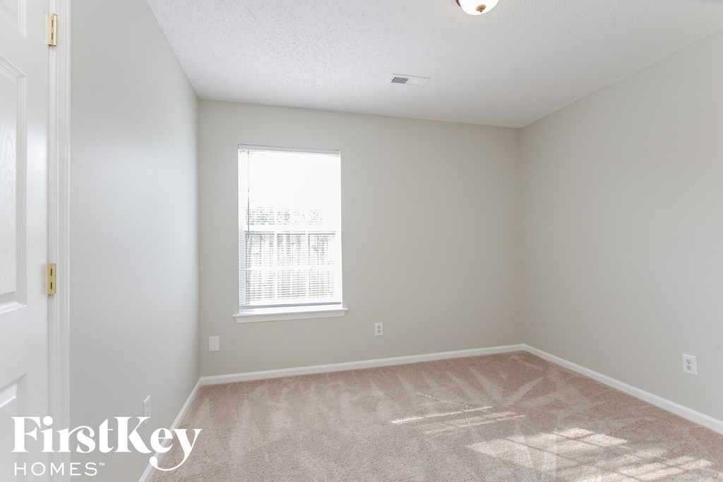 a bedroom with a carpeted floor and a window