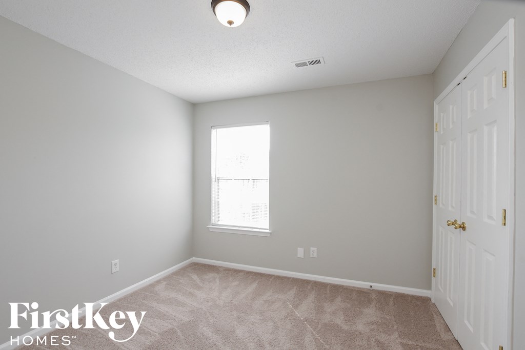 a bedroom with a white door and a window