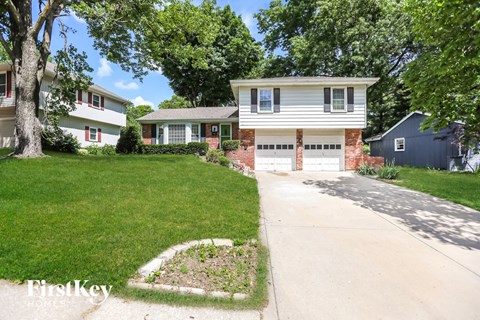 a white house with a driveway and a garage door