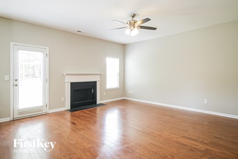 A room with a fireplace and a ceiling fan.