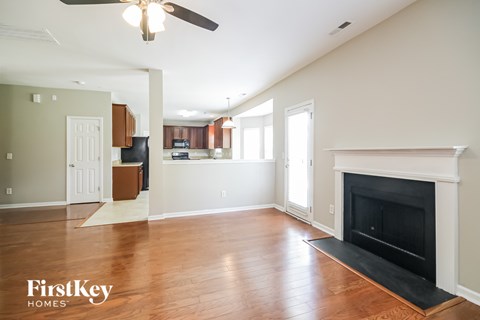 A living room with a fireplace and a ceiling fan.
