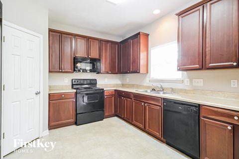 A kitchen with brown cabinets and black appliances.