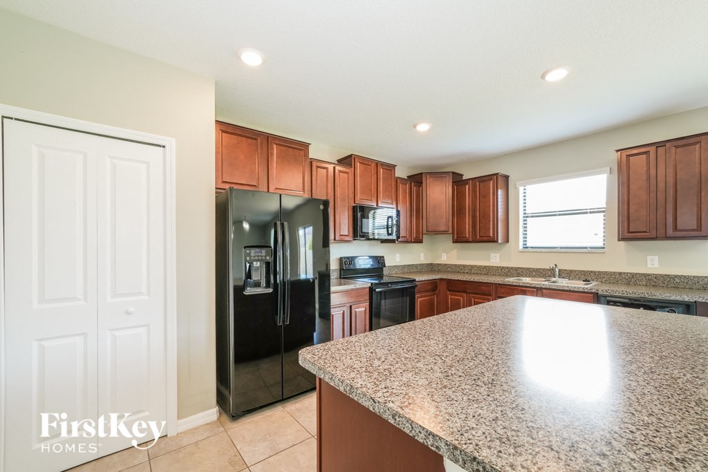 a kitchen with granite countertops and black appliances