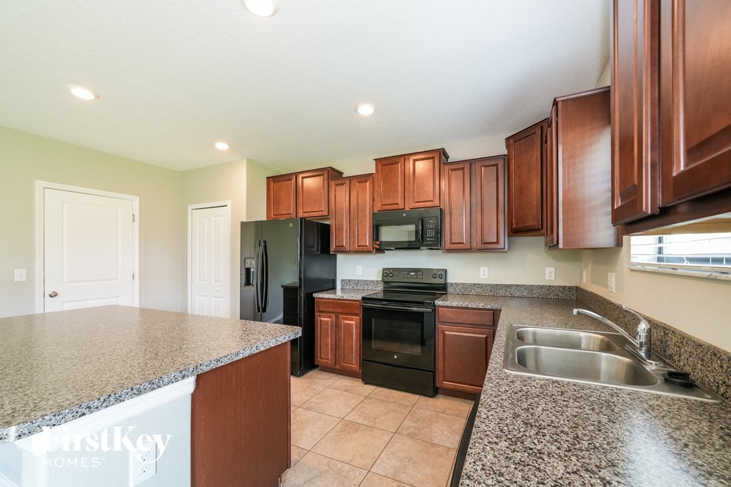 a kitchen with black appliances and granite counter tops