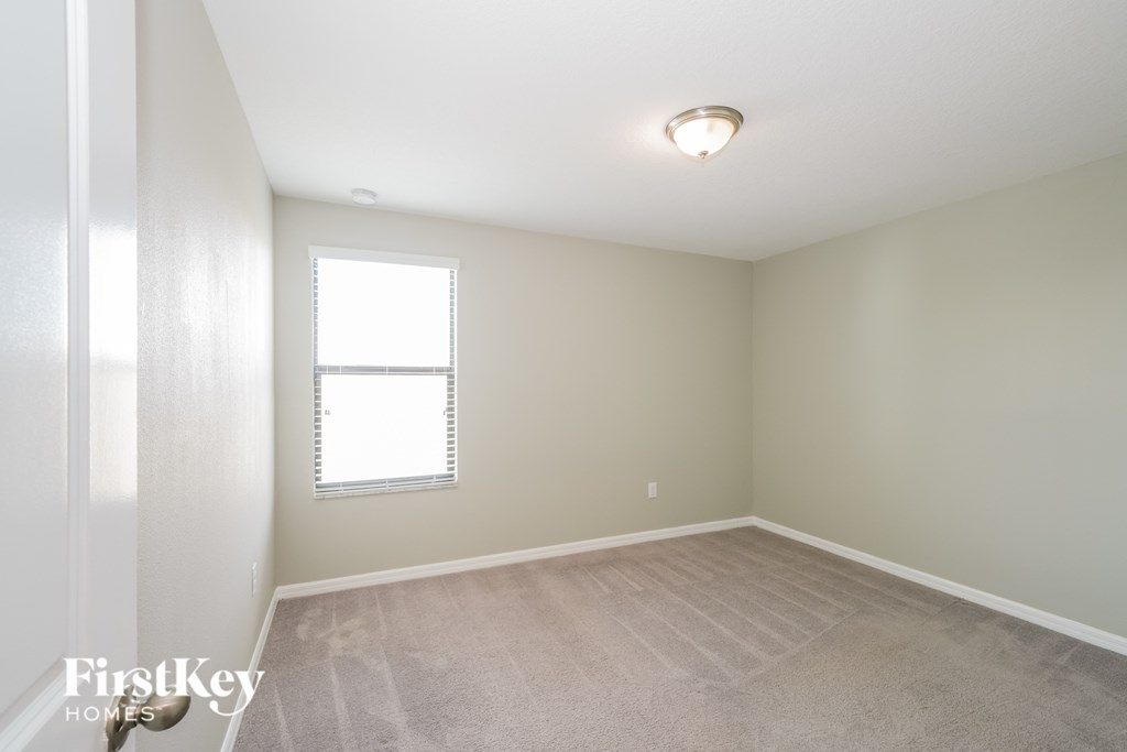 an empty room with a window and a carpet