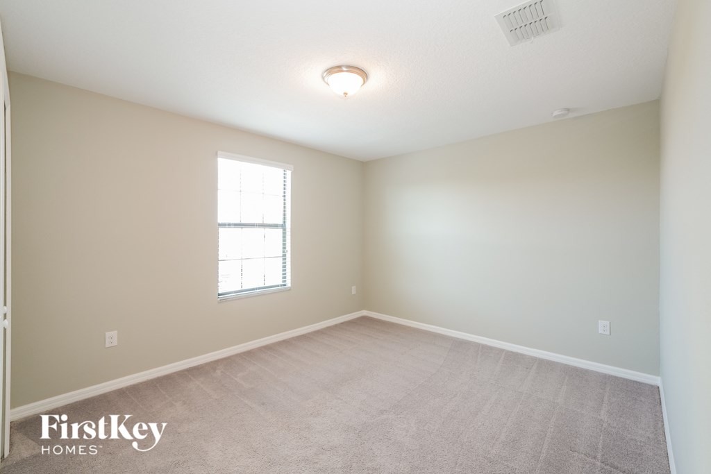 a bedroom with a carpeted floor and a window