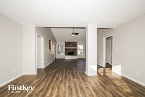 A spacious room with wooden floors and white walls.