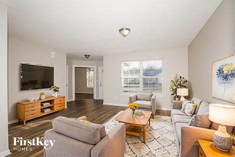 A living room with a grey couch, a wooden coffee table, and a painting on the wall.