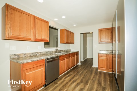 A kitchen with wooden cabinets and a granite countertop.