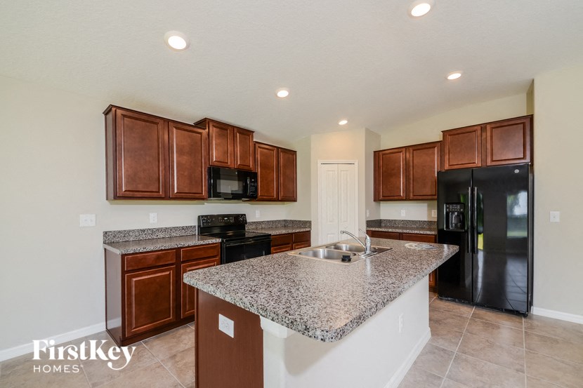 a kitchen with granite countertops and black appliances