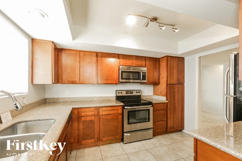 A kitchen with wooden cabinets and a stainless steel oven.