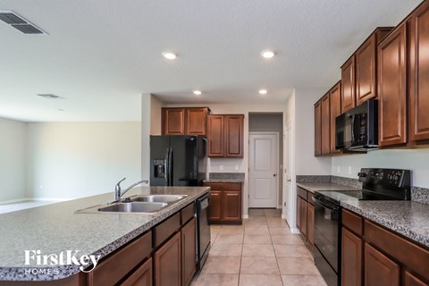 a kitchen with granite counter tops and wooden cabinets