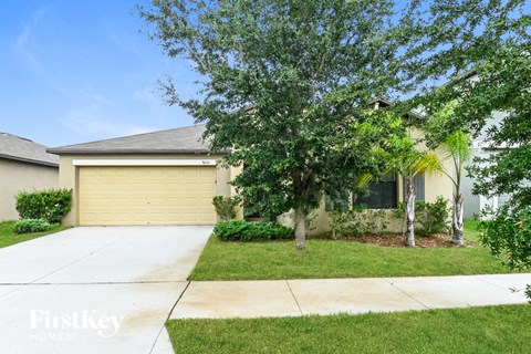 a home with a yellow garage door and a tree