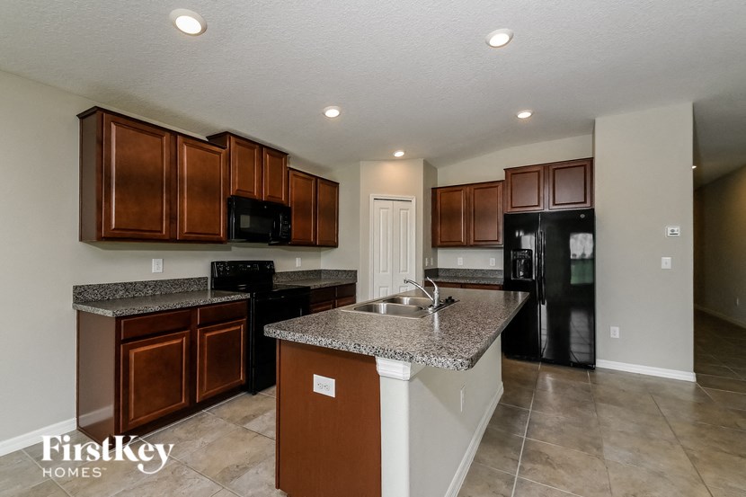 a kitchen with granite counter tops and black appliances