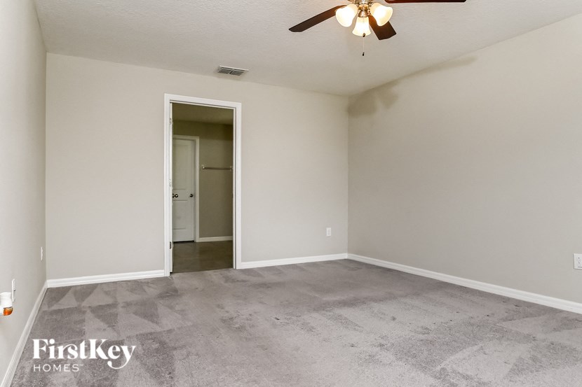 an empty living room with a ceiling fan