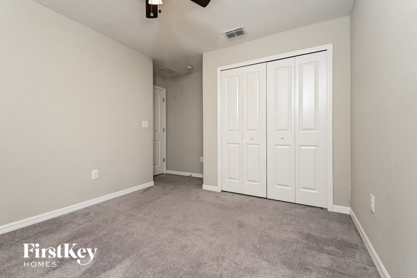 a bedroom with two closets and a carpeted floor