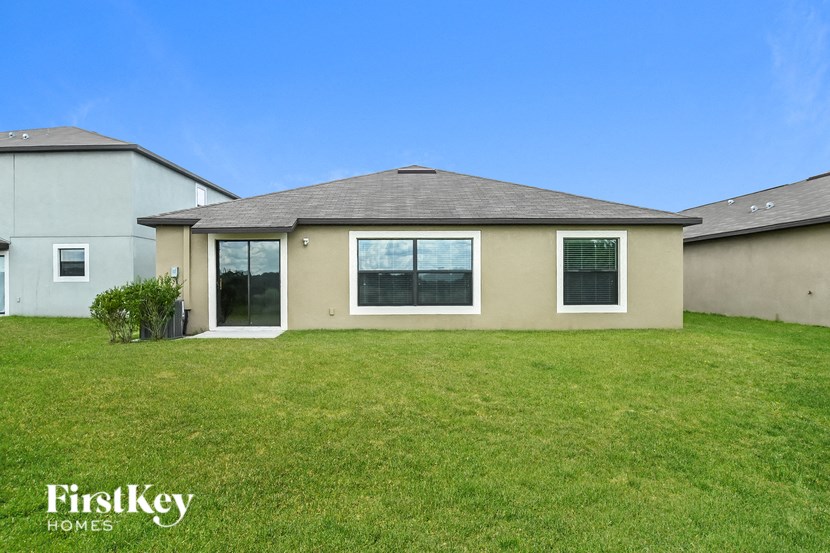 a beige house with a lawn and a blue sky